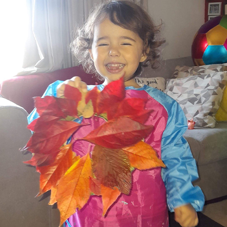 Early years child with art and craft leaf wreath
